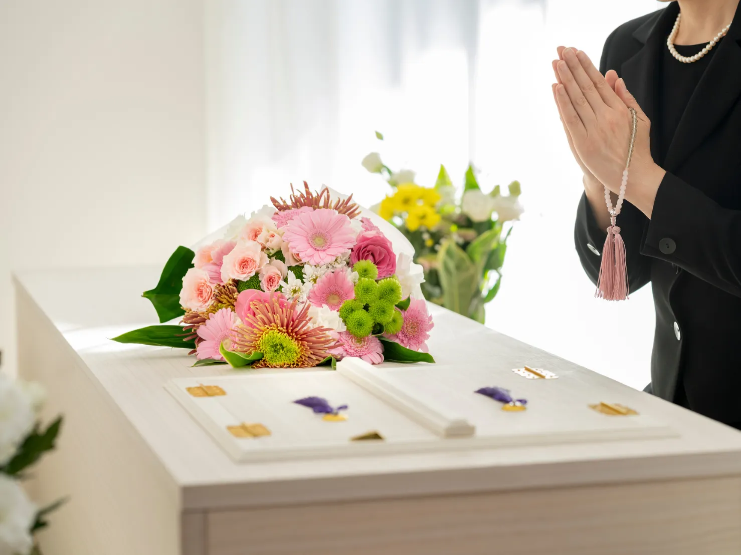 火葬式プランのイメージ画像、お棺と合掌する女性の写真